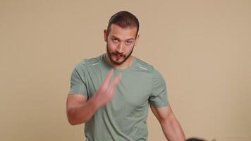 Athlete sportive man pointing at eyes and camera, show I am watching you gesture, start working out video