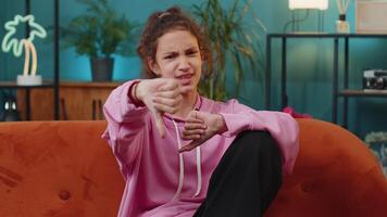 Upset school girl showing thumbs down, dislike bad work, disapproval, dissatisfied feedback at home video