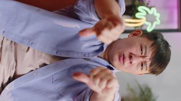 Upset asian man showing thumbs down, dislike bad work, disapproval, dissatisfied feedback at home video