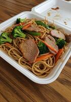 A white container with meat and vegetables photo