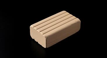 A block of cream colored soap on a black surface photo