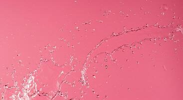 Water splashing on a pink background photo
