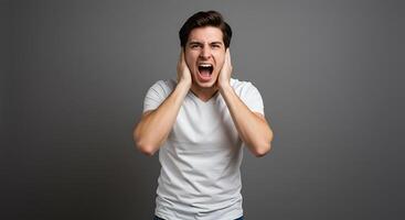 A man screaming in front of a gray background photo