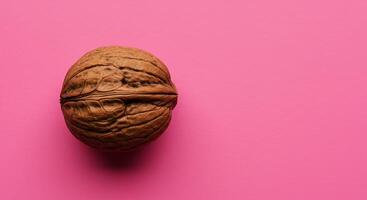 A walnut on a pink background photo
