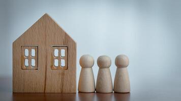Wooden House Model and Figurines on a Table with Blurred Background photo