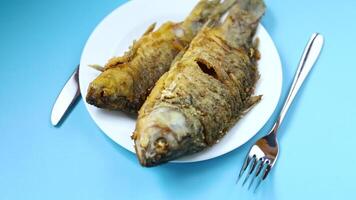 Appetizing fried crucian carp with butter and spices in a frying pan video