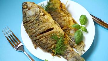 Appetizing fried crucian carp with butter and spices in a frying pan video