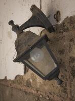 Rustic lantern hangs at an abandoned site, casting an aura of nostalgia and mystery in the dim light of dusk photo