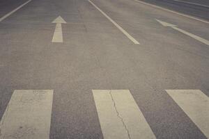 Guiding lines on an empty street stretch toward the horizon under a cloudy sky at dusk photo