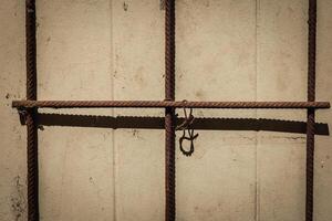 Rusty metal bars casting shadows on a weathered wall in the warm afternoon light of a serene urban setting photo