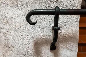 Old iron hook showcasing rustic craftsmanship in a vintage setting of natural textures and subdued colors photo