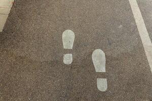 Footsteps guiding the way on a quiet urban pathway during a sunny afternoon stroll photo