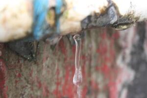 a close up of a pipe with water dripping from it photo