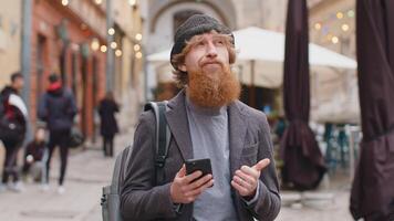 Young man using smartphone typing text messages looking for a way on map in mobile navigator app video