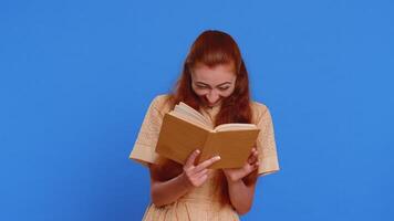 Redhead adult woman reading funny interesting fairytale story book, leisure hobby, learning, study video