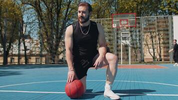 Portrait of tired smiling athletic lebanese man in sportswear relaxing after playing basketball game video