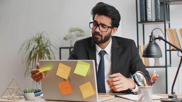Tired sad exhausted businessman working on laptop at office with many sticker tasks, panic attack video