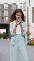 Preteen girl use smartphone typing text messages browsing internet finishing work looking at camera video