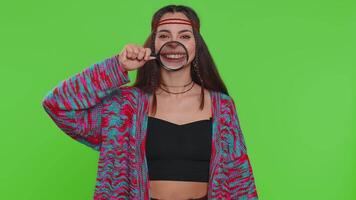 Woman holding magnifier glass loupe on teeth looking at camera showing funny smiling face mouth video