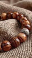Wooden beads arranged on a textured fabric, showcasing natural patterns and craftsmanship in a serene setting photo