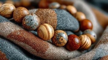 Natural wooden beads arranged on a textured fabric with a unique pattern during daylight photo