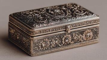 Intricate silver jewelry box with floral patterns and detailed engravings showcased on a neutral background photo
