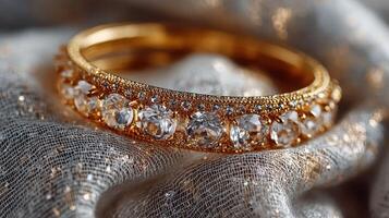 Elegant gold bracelet adorned with sparkling gems resting on luxurious fabric photo