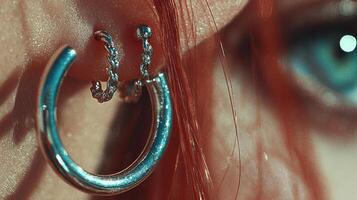 Close-up of a stylish silver earring accentuating vibrant red hair and captivating blue eye details photo