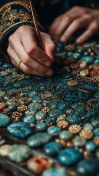 Skilled artisan creating intricate patterns with gemstones on a vibrant surface in a cozy workshop setting photo