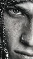 Close-up of a person displaying intense expression and unique accessories in a monochrome style photo