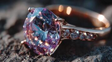 Beautiful engagement ring featuring a large purple gemstone set in rose gold on a textured surface in natural light photo