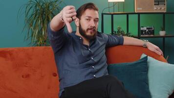 Upset lebanese man showing thumbs down, dislike bad work, disapproval, dissatisfied feedback at home video