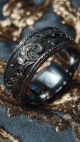 Intricate silver ring with ornate design resting on textured background fabric photo