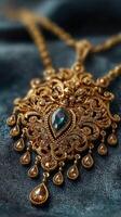Intricate gold necklace with gemstone design displayed on dark fabric background photo