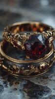 Elegant vintage rings with deep red gemstones displayed on a textured surface photo