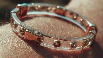 Elegant transparent bracelet with metallic accents glistening under sunlight on a person's wrist during outdoor activity photo