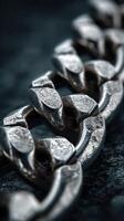 Close-up view of a metallic chain highlighting texture and detail against a dark background photo