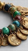 Unique blend of colorful stones and gold coins forms an exquisite jewelry piece showcasing craftsmanship and artistry photo