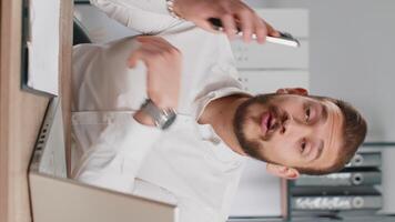 Young business man showing smartphone asking to make telephone conversation gesturing call me sign video