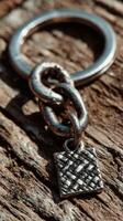 Metal keyring with intricate charm resting on weathered wooden surface in soft natural lighting photo