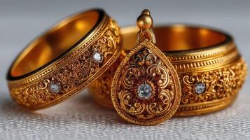 Exquisite gold jewelry with intricate designs on rings and a pendant showcasing elegance and craftsmanship photo