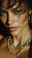 Portrait of a woman with glowing skin and layered necklaces captured in warm lighting photo