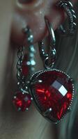 Unique heart-shaped red gemstone earrings with intricate silver detailing showcased in close-up view photo
