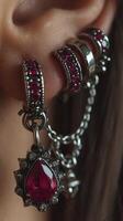 Jewelry display showcasing intricate earrings with ruby stones worn by a model in a close-up setting photo