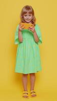 Preteen child kid girl enthusiastically playing racing or shooter games on smartphone app video