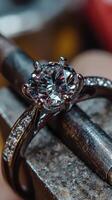 Sparkling diamond engagement ring displayed on a workbench in a jewelry workshop during the crafting process photo