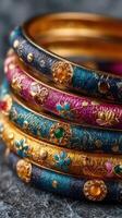 Colorful bangles displayed together with intricate designs and metallic accents on a textured surface photo