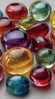 Vibrant collection of glass gems in various shapes and colors on a reflective surface at a craft market photo
