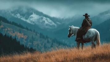 Handsome cowboy atop white horse gazes at majestic mountains on a cloudy day during the fall photo