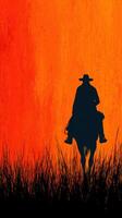 Cowboy silhouette against vibrant sunset in open grassland near the horizon photo